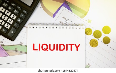 Liquidity On Notepad With Calculator, Coins, Graphics On Financial Report. Business And Financial Concept