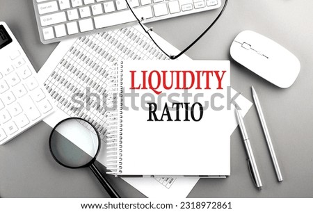 LIQUIDITY RATIO text on notepad on chart with keyboard and calculator on a grey background