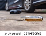 Liquor Alcohol Bottle fell on The Floor with car and shoe background.don