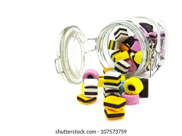 Liquorice allsort sweets in storage jar isolated over white background.