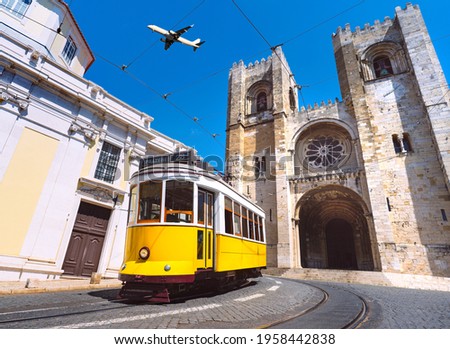 Lisbon city old town and famous yellow tram 28 in front of Santa Maria cathedral on a sunny summer day. Trams in Lisbon, Portugal. Tourist attraction