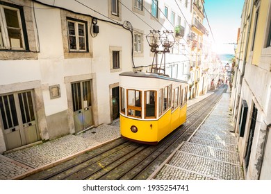 Lisbon city old town narrow streets and tram, Portugal. Famous retro yellow funicular tram on a sunny summer day