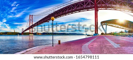 Lisbon landscape at sunset.Panoramic photograph of the 25 de Abril bridge in the city of Lisbon over the Tajo River