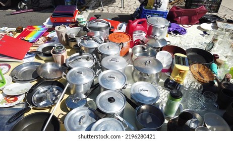 Lisbon, Portugal - 06-08-2022 - Old Cookware Pots At A Tent Store At Feira Da Ladra Open Market Fair, And Tourists Buying.