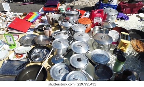 Lisbon, Portugal - 06-08-2022 - Old Cookware Pots At A Tent Store At Feira Da Ladra Open Market Fair, And Tourists Buying.