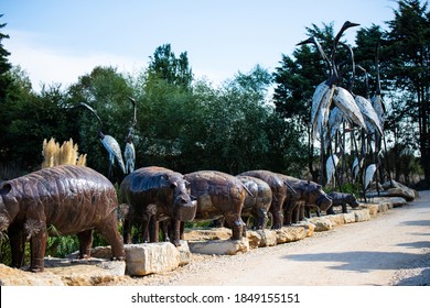 Lisbon, Portugal: 09/08/2020: Hiding part of the Buddha Garden with the african and wild animals sculptures (crocodile, giraffe, snake, monkey) in brass material.  Buddha Eden, asian style garden.
