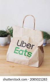 Lisbon,  Portugal - 11.26.2021: A Delivery Bag Uber Eats On A Wooden Table On A Kitchen 