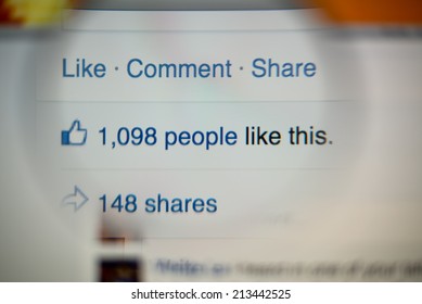 LISBON, PORTUGAL - AUGUST 27, 2014: Photo of Facebook notifications of Likes and Shares on a monitor screen through a magnifying glass.