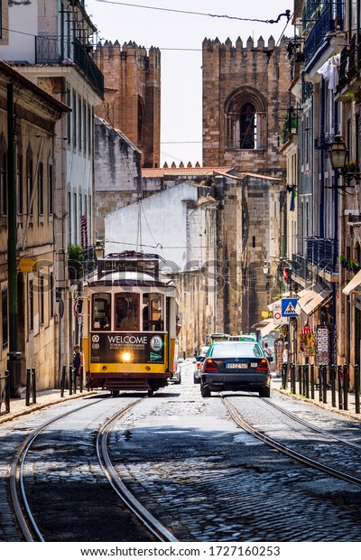 LISBON, PORTUGAL - CIRCA 2016: A Tram\
and a Car Pass on the Street in Lisbon,\
Portugal