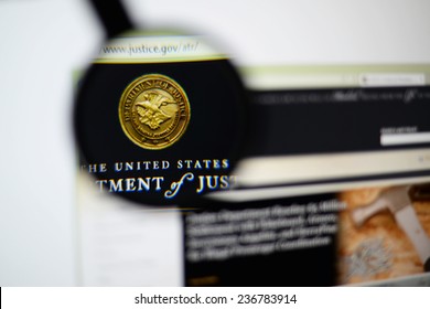 LISBON, PORTUGAL - December 9, 2014: Photo of the United States Department of Justice (DOJ) homepage on a monitor screen through a magnifying glass.  
