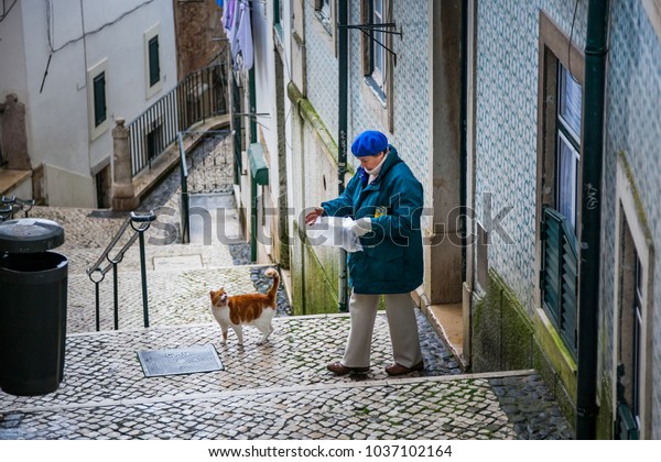 LISBON, PORTUGAL -\
January 28, 2011: unknown woman donates to eat the cat in the\
Alfama neighbourhood, the old quarter of Lisbon, Historical\
Province of Extremadura,\
Portugal