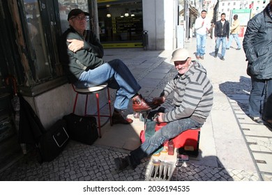 LISBON, PORTUGAL - JULY 10, 2019: Man cleaning shoes in the streets of Lisbon - Shutterstock ID 2036194535