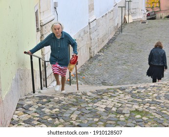 Lisbon - Portugal - March 14, 2020: Portrait Of A Senior Older Woman With White Hair Climbing Stairs In Historic Alfama Area. 