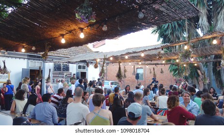 LISBON, PORTUGAL - MAY 24, 2018: People Dinner And Enjoying Live Music In The LX Factory Community Space Under The 25th Of April Bridge In The Alcantara District