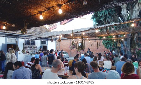 LISBON, PORTUGAL - MAY 24, 2018: People Dinner And Enjoying Live Music In The LX Factory Community Space Under The 25th Of April Bridge In The Alcantara District