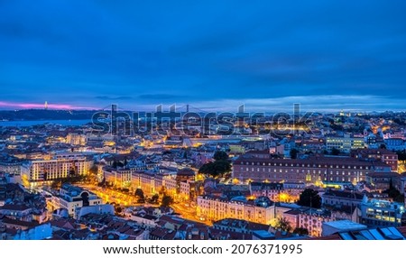 Lisbon in Portugal at night with the Sanctuary of Christ the King and the 25 de Abril Bridge in the back
