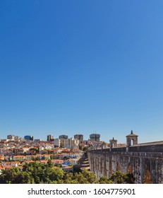 LISBON, PORTUGAL - OCTOBER 10, 2019: Águas Livres Aqueduct With Cityscape On A Background On A Sunny Day, Vertical Crop.