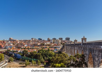 LISBON, PORTUGAL - OCTOBER 10, 2019: Águas Livres Aqueduct With Cityscape On A Background On A Sunny Day, Horizontal Crop.