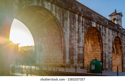 LISBON, PORTUGAL - OCTOBER 8, 2019: Evening Sun Visible Through One Of Águas Livres Aqueduct Arches.