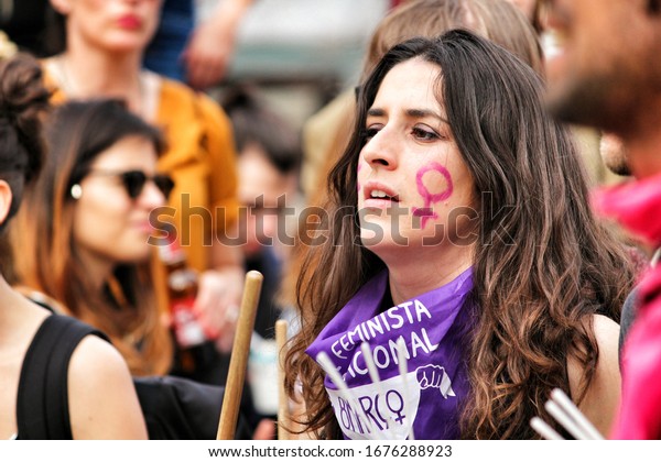Lisbon, Portugal-March 8, 2020:\
People protesting at Camoes Square showing feminist banners, flags\
and protest placards in Lisbon for the International Women\'s\
Day