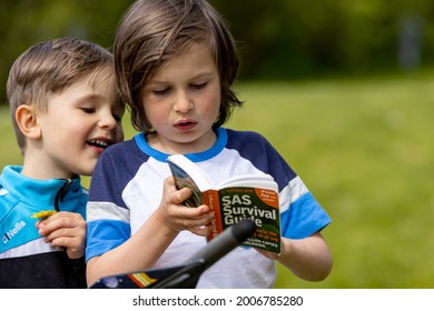 Lisburn Northern Ireland United Kingdom May 7 2021 Two Boys Outside Reading Special Air Service Survival Guide Book