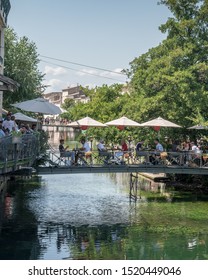 L'Isle- Sur-la-Sorgue, France / 18 SEP 2019: Unidentified Diners Enjoying Sunday Brunch In An Outdoor Café On A Bridge Over The Sorgue River In Provence.