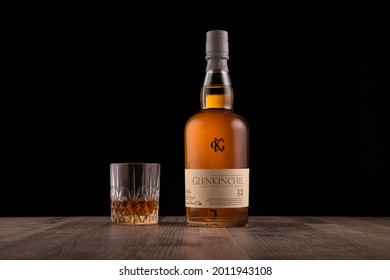 LISSE, THE NETHERLANDS - JULY 17, 2021: Glenkinchie Bottle And Glass Of Scotch 12 Year Old Whisky On A Wooden Surface Against A Black Background. (landscape Orientation)