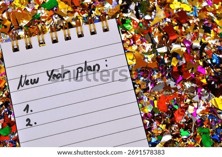 list with new year plan between shiny colorful confetti
