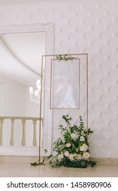 List, plan, chart of the seating area of guests at the tables at restaurant. Tables wedding guests on the easel on wedding reception. The frame is decorated with green flowers and greenery.