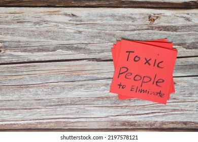 List Of Toxic People To Eliminate Concept. Red Sticky Note In Wooden Background With Copy Space.