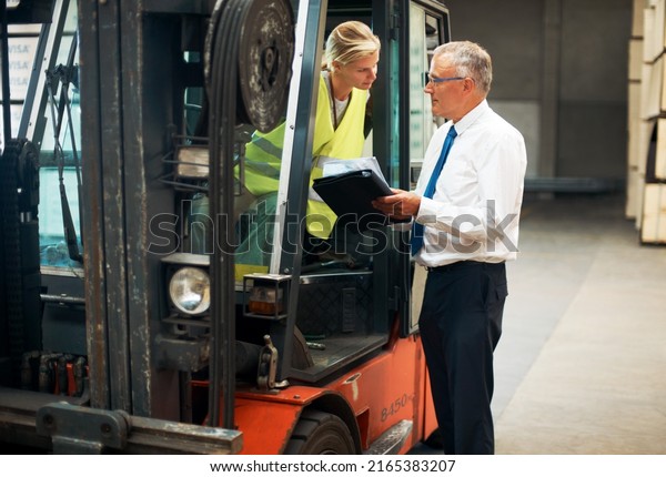Listen and learn from the\
best. A manager giving orders to an employee who\'s sitting on a\
forklift..