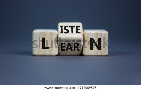 Listen\
and learn symbol. Turned a wooden cube and changed the word\
\'listen\' to \'learn\'. Beautiful grey background, copy space.\
Business, education and listen and learn\
concept.