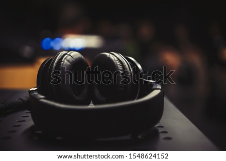 Listen to the music with professional headphones.Big black headset with powerful bass sound.Stereo head phones on concert stage.High quality head monitors for musician 