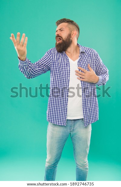 listen to\
my song. caucasian guy with beard and mustache singing serenade.\
mature male singer hold his heart. hipster talking with gesture.\
romantic bearded man in casual checkered\
shirt.