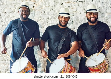 Listen to our Samba sounds. Cropped portrait of a group of handsome young male drummers playing at Carnival. - Powered by Shutterstock