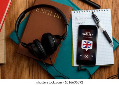 Listening to English speech. Using podcast app and headphones for better learning and improving vocabulary with new words. - Shutterstock ID 1016636392