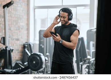 Listening, headphones and man with cellphone in gym, athlete and ready for workout, fitness and training. Health club, guy and routine of exercise in morning, ambition and preparing of competition - Powered by Shutterstock