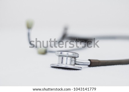 The stethoscope is an acoustic medicaldevice for auscultation, or listening to the internal sounds of an animal or human body  on white background , soft focus , blurred, out of focus.