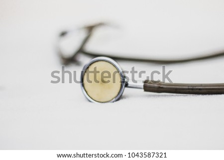 The stethoscope is an acoustic medicaldevice for auscultation, or listening to the internal sounds of an animal or human body on white background , soft focus , blurred.