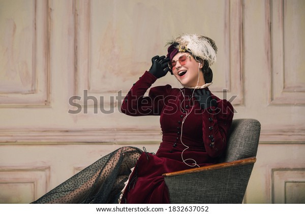 Listening to music in earphones. Modern\
trendy look of Portrait of an Unknown Woman. Retro style,\
comparison of eras concept. Beautiful caucasian female model like\
classic art character,\
old-fashioned