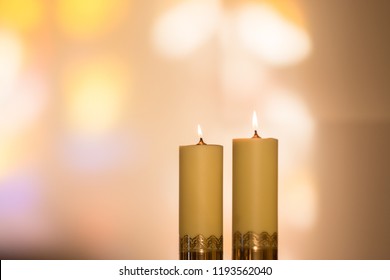 Lit candles during catholic church mass with bokeh background, closeup - Shutterstock ID 1193562040