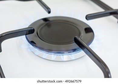 A Lit Gas Ring On The Hob Of A White Cooker