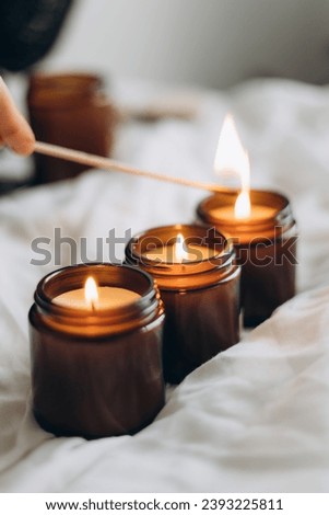 lit handmade scented candles in glass jars