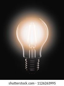 Lit Light Bulb With LED Filament On A Black Background.