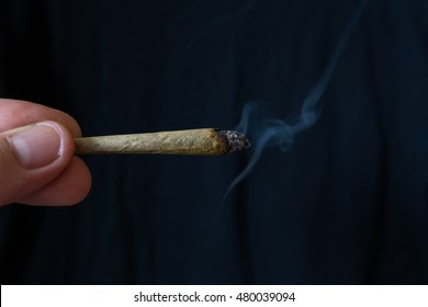 Lit smoking cannabis or marijuana cigarette joint