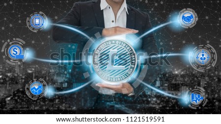 Litecoin and cryptocurrency investing concept - Businessman holding Litecoin (LTC) with mobile application business icons showing exchanging, trading, transfer and investment of blockchain technology.