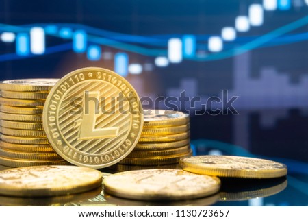 Litecoin (LTC) and cryptocurrency investing concept - Physical metal litecoin coins with global trading exchange market price chart in the background.