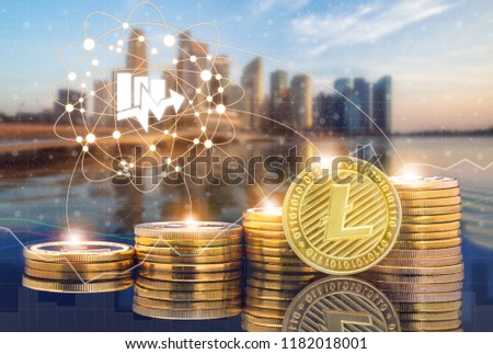 Litecoin LTC and cryptocurrency investing concept - Physical Litecoin coins with city background and exchange market trading price chart. Blockchain and financial technology.
