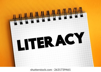 Literacy is the ability to read, write, speak and listen, text concept on notepad