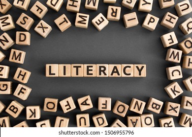 literacy - word from wooden blocks with letters, basic skill or knowledge literacy concept, random letters around, top view on wooden background